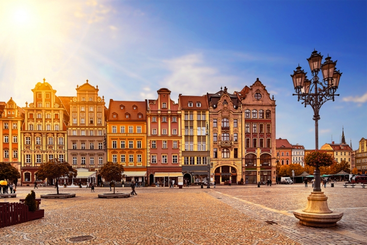 Zentraler Marktplatz in Breslau Polen mit alten bunten Häusern,Straßenlaterne Lampe und gehende Touristenleute am herrlichen erstaunlichen Morgensonnenaufgangsonnenschein. Reise-Urlaub-Konzept