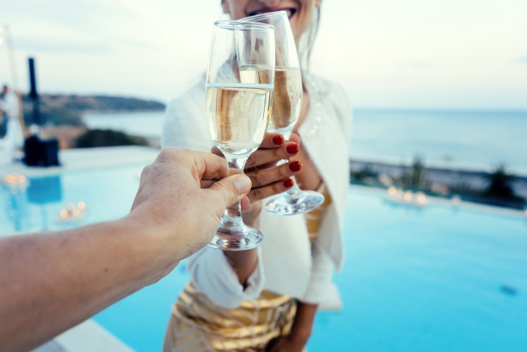 Frau und Mann stoßen an auf Pool und Strandparty