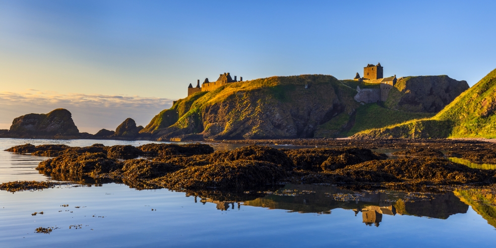 Dunnottar Castle bathed in morning sunlight, taken from Castle Haven near Stonehaven in Aberdeenshire.