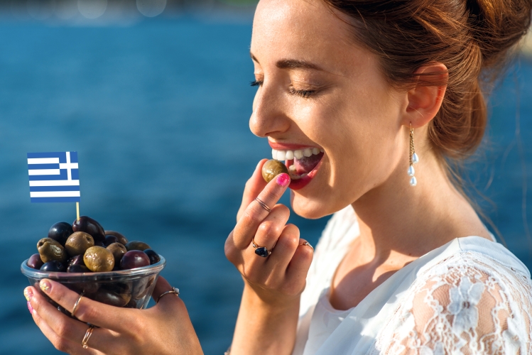 Frau, die griechische Oliven isst